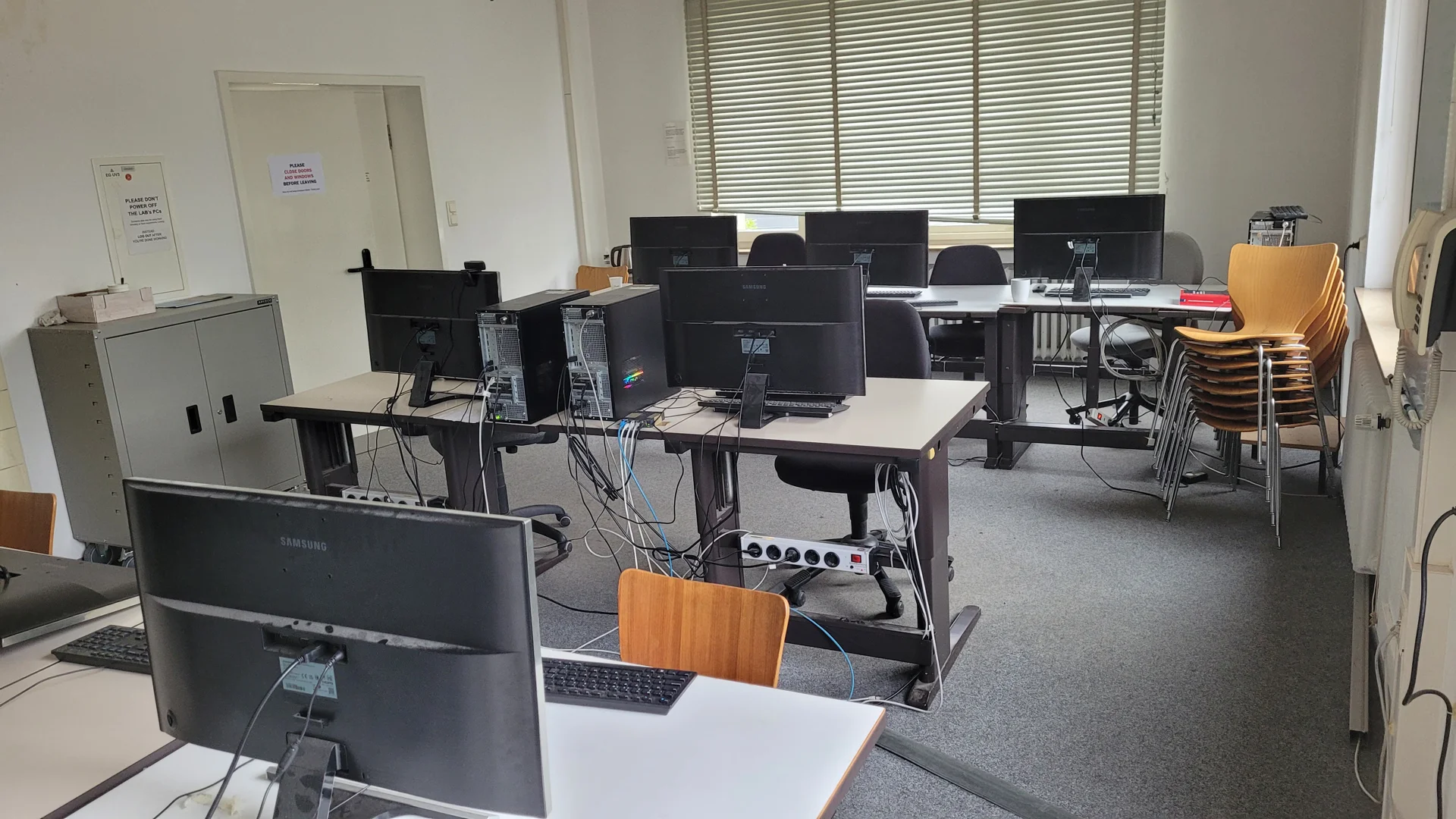 Blick über die Stuhlreihen hinweg auf Tafel und Leinwand